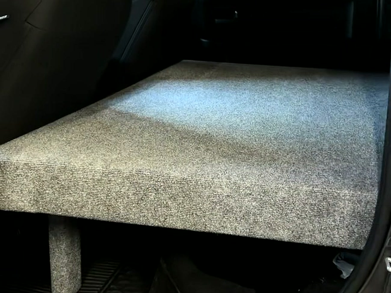 Custom carpeted storage and sleeping platform built into the crew cab